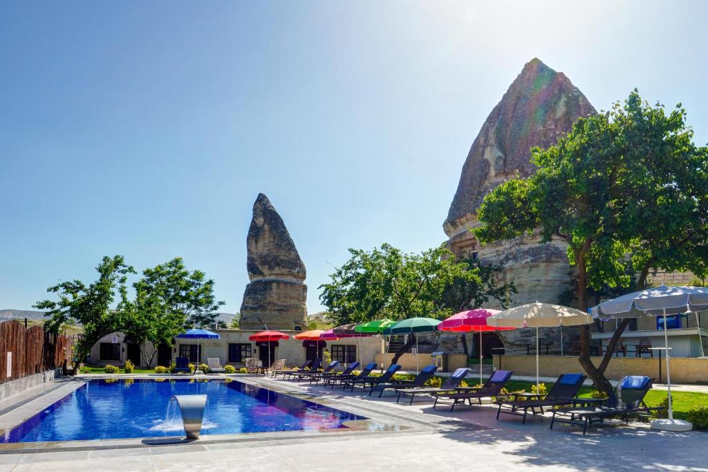 a pool at the resort with chairs and umbrellas at A La Mode Cappadocia in Göreme