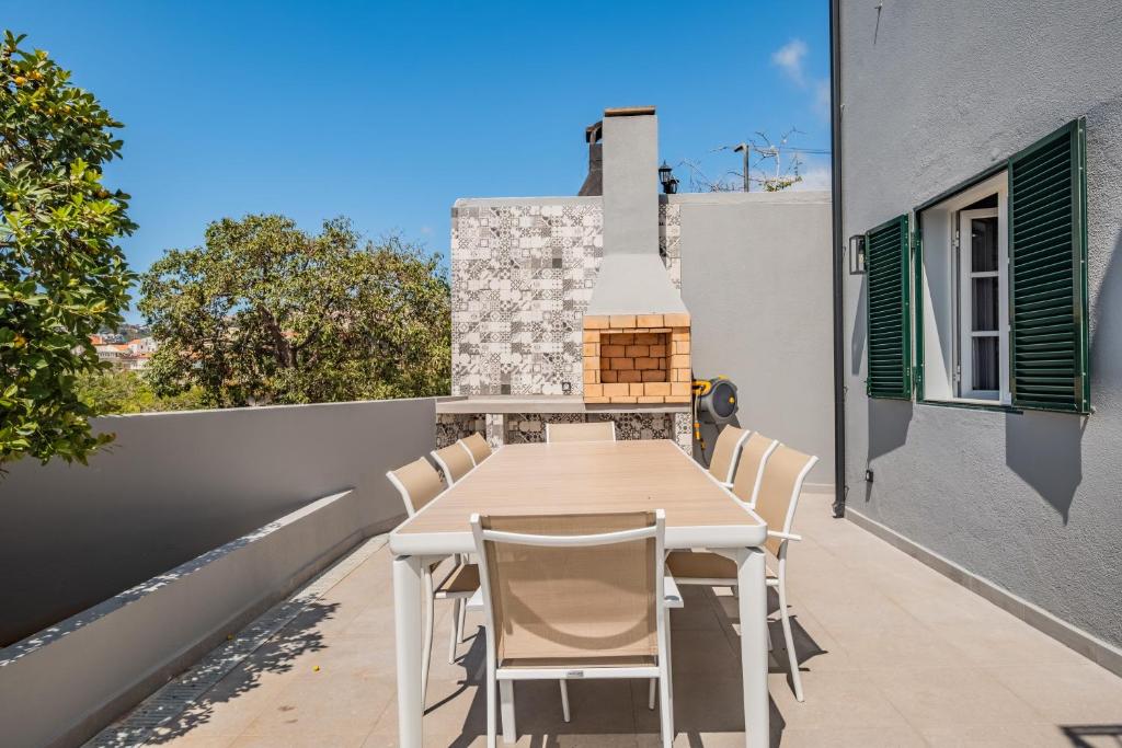 a table and chairs on the balcony of a house at Villa Pedreiro in Funchal