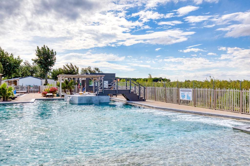 a swimming pool with a slide in the water at Mobilhome 6 pers au Castellas in Mèze