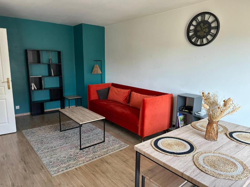 un salon avec un canapé rouge et une table dans l'établissement Appartement Saint Maurice avec parking, à Lille