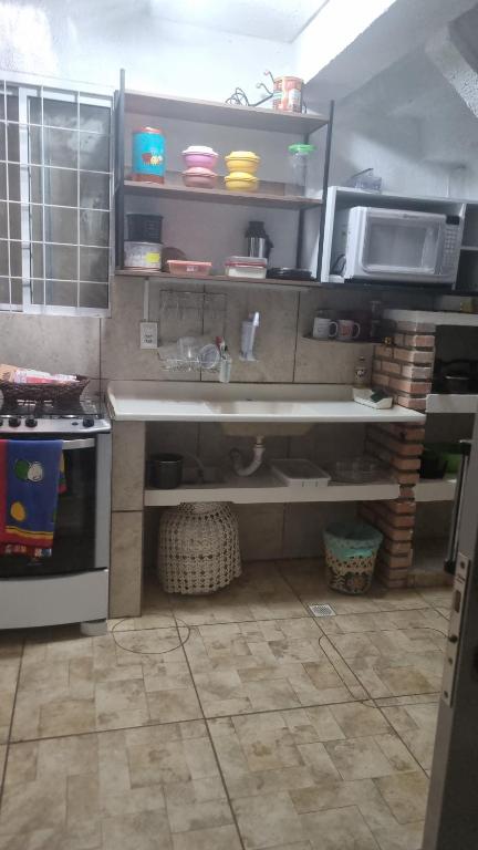 a kitchen with a sink and a microwave and a stove at Casa Margarida in Brasília