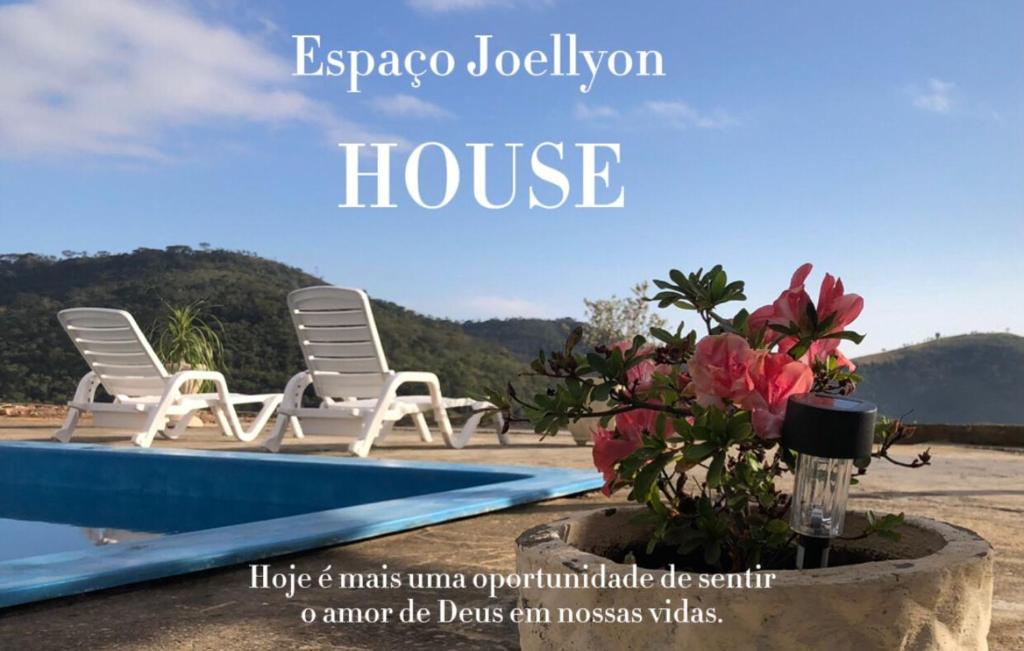 due sedie e fiori accanto a una piscina di Casa de campo a Paty do Alferes