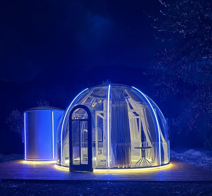 a clear igloo with a table in it at night at Glamping & Spa Luna Azzurra in Sulmona