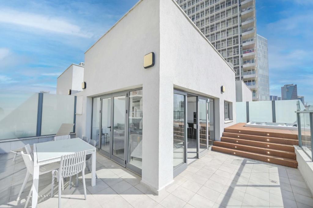 ein Balkon mit Tisch und Stühlen auf einem Gebäude in der Unterkunft Modern 3 BR Penthouse with Jacuzzi in Rothschild Blvd by HolyGuest in Tel Aviv