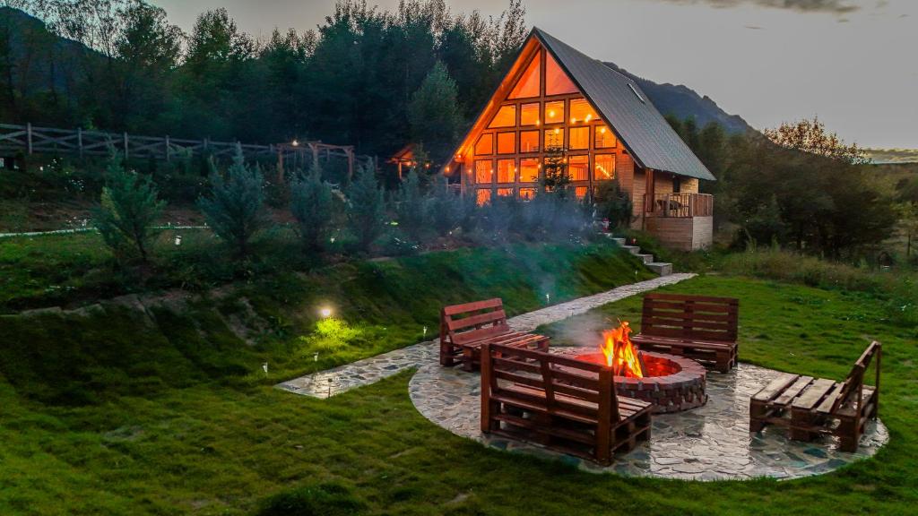 a fire pit in front of a house with benches at Cabana Timbernest in Bran