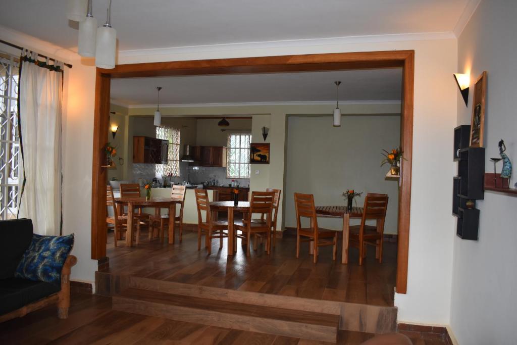 a dining room and kitchen with a table and chairs at Kili Kivuli in Msaranga