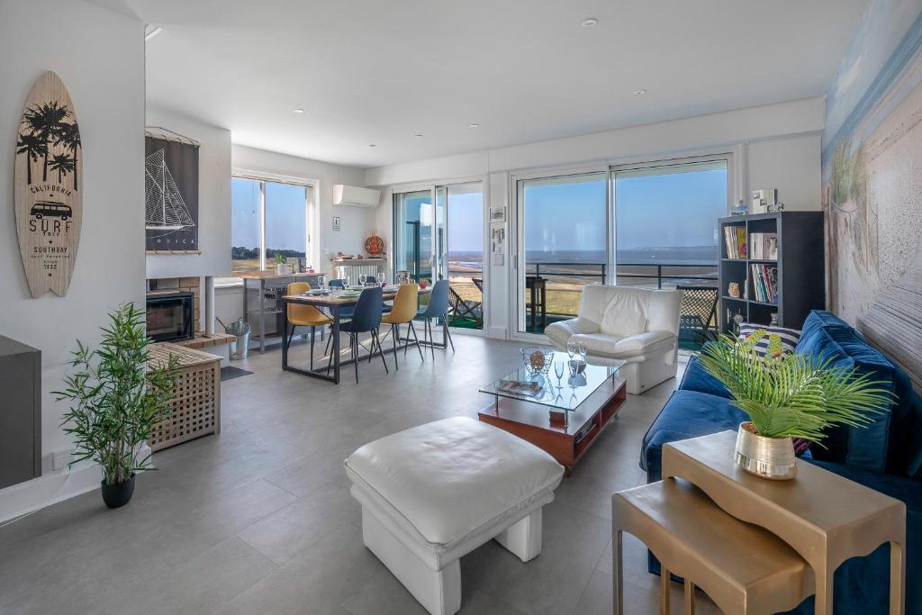 een woonkamer met een blauwe bank en een tafel bij Appart vue mer pour 4 à St Brevin les Pins in Saint-Brevin-les-Pins