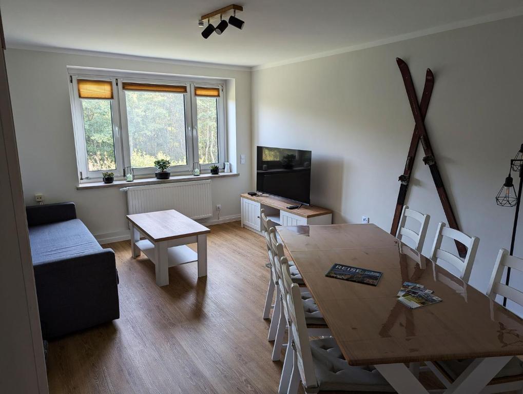 a dining room with a table and chairs and a television at FeWo Bergsonne - 2 Schlafzimmer, modern, Familie, ruhige Lage in Kurort Oberwiesenthal