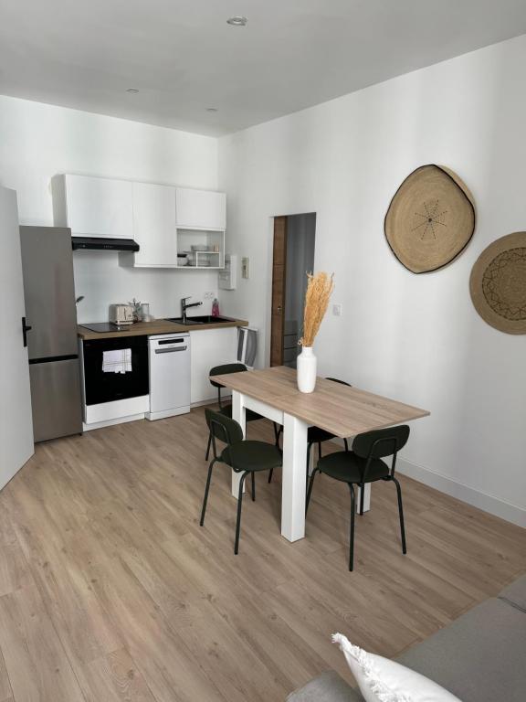 une cuisine et une salle à manger avec une table et des chaises en bois dans l'établissement O cosy, à Avignon