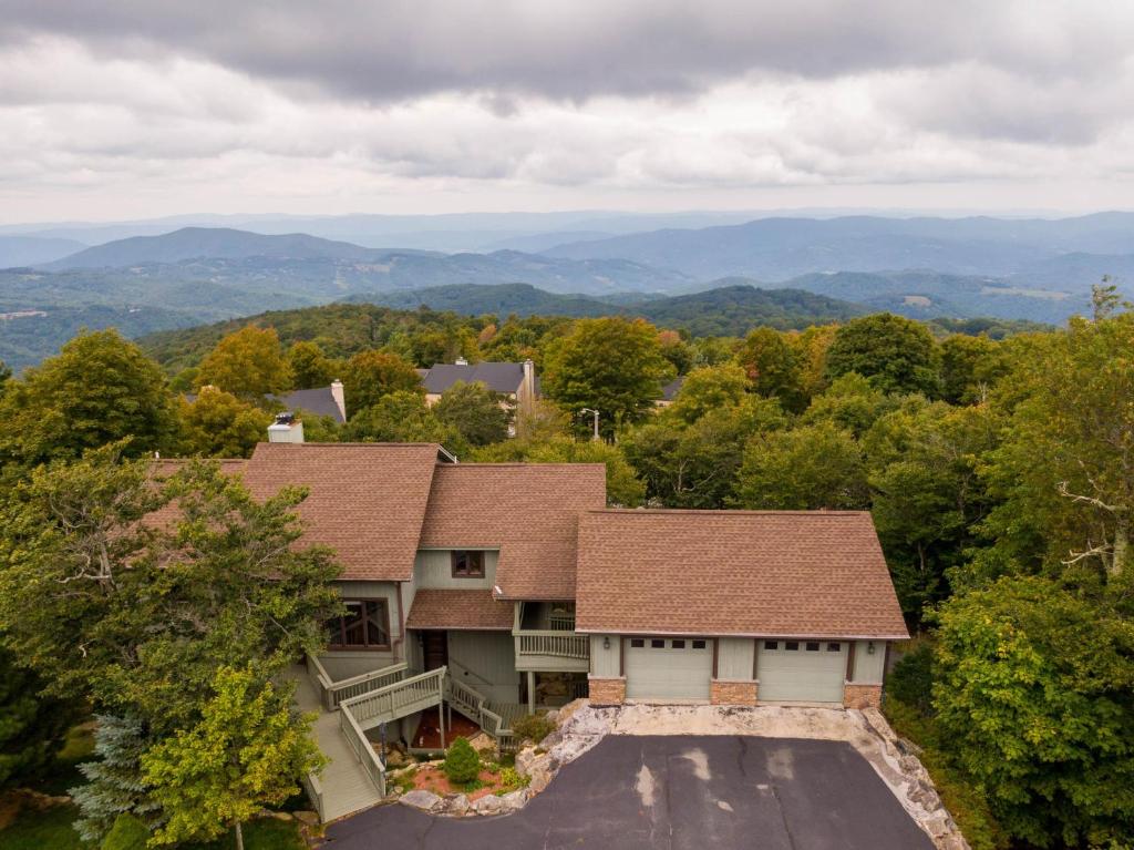an aerial view of a house with mountains in the background at Hill Station in Beech Mountain