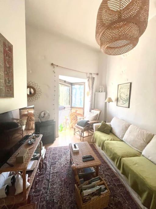 un salon avec un canapé vert et une table dans l'établissement Charme des Lices, à Arles