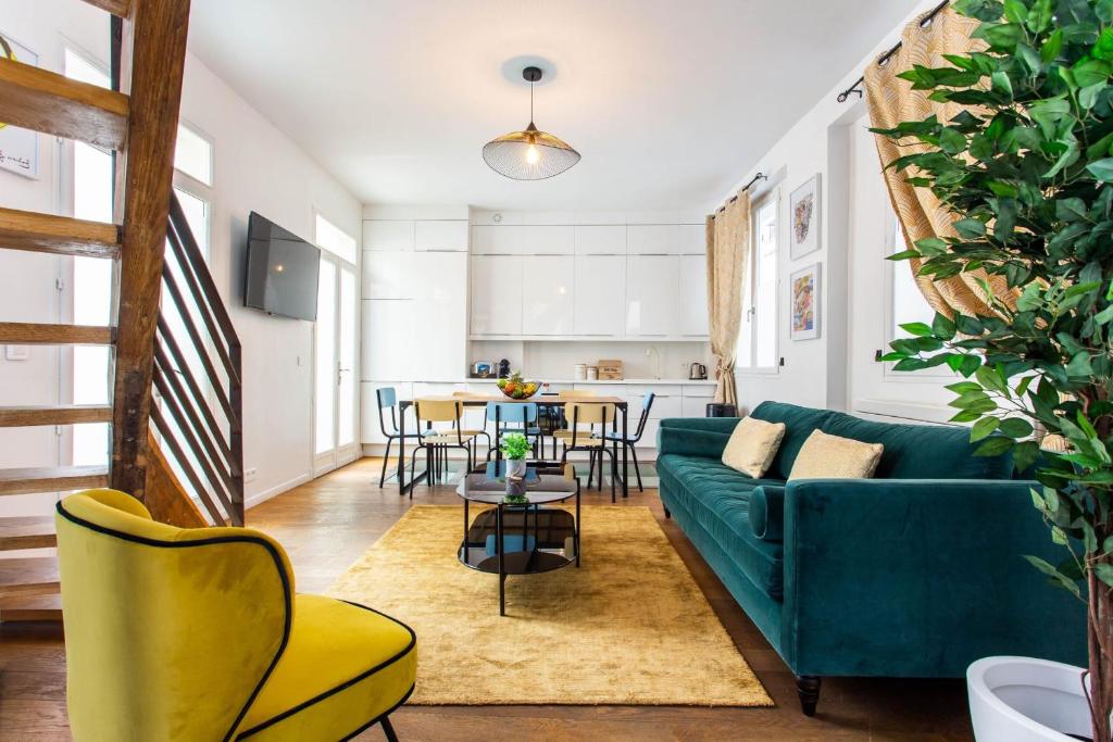 un salon avec un canapé bleu et une table dans l'établissement Authentic apartment - 4BR-10P - Moulin Rouge, à Paris