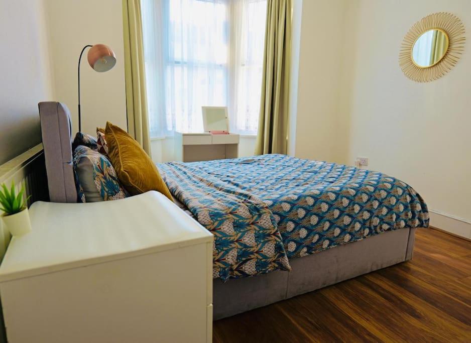 Hotel Two bedroom flat near transport & shops, a bedroom with a bed with a blue comforter at Two bedroom flat near transport & shops in London