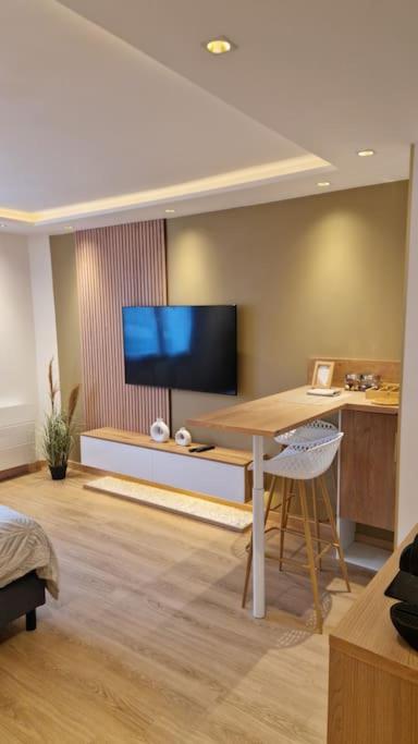 un salon avec un bureau et une télévision dans l'établissement L'écrin Doré, à Vernon