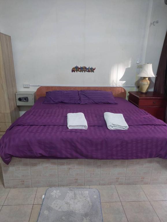 Postel nebo postele na pokoji v ubytování PLUEMCHAI Guesthouse