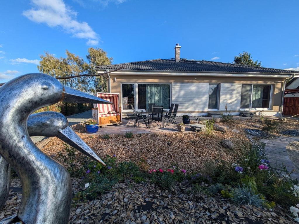 a statue of a swan in front of a house at "Natur-Retreat am Bodden mit Kranichbeobachtung"-Haus kleiner Kranich in Neuendorf Hof