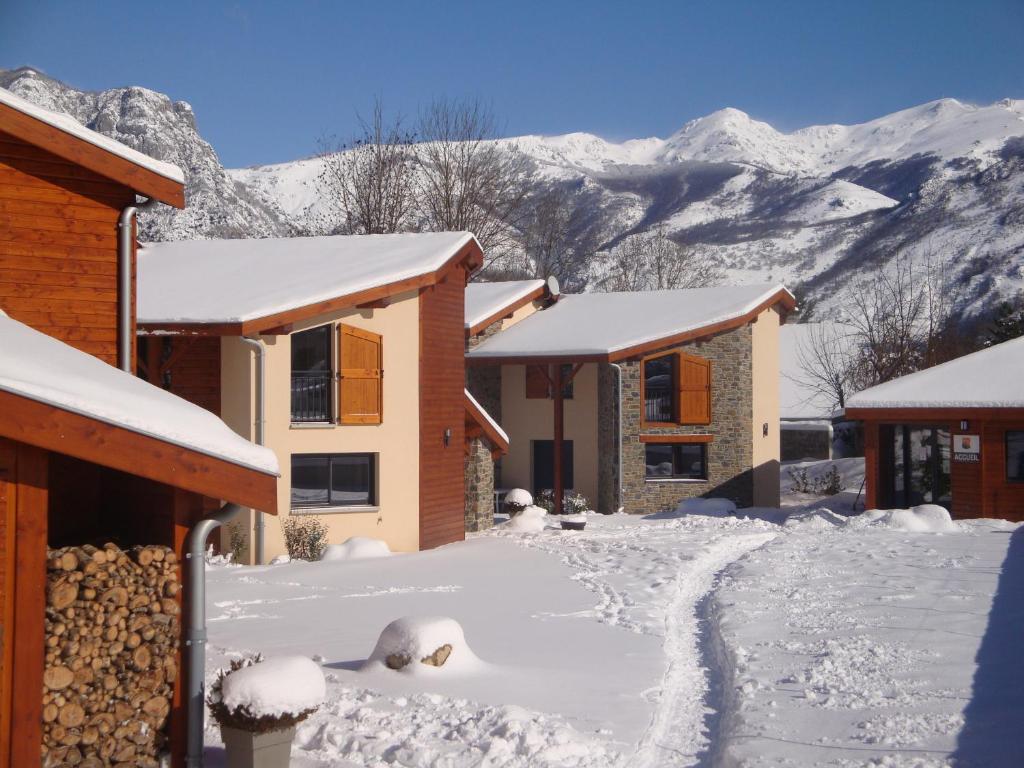 a house covered in snow with mountains in the background at Les Granges de Leo in Aston