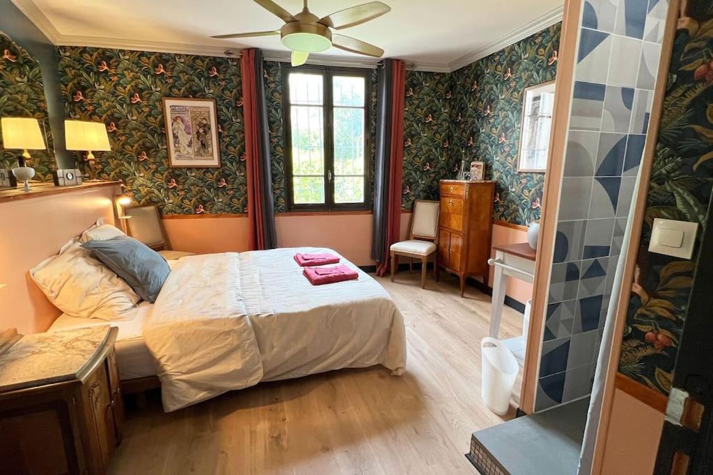 a bedroom with a bed in a room with wallpaper at Maison Intramuros 3 chambres 3 salles de bain - Idéal Festival in Avignon