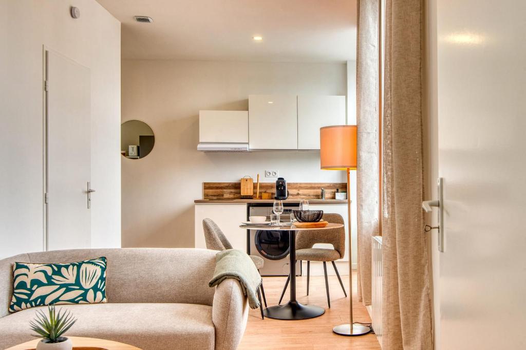 un salon avec un canapé et une table dans l'établissement L'Amandier - Superbe appart au coeur de Lyon 5, à Lyon