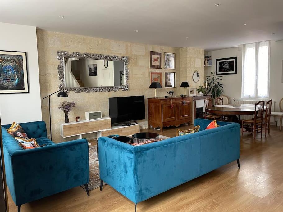un soggiorno con 2 divani blu e una TV di Bordeaux centre Maison calme a Bordeaux