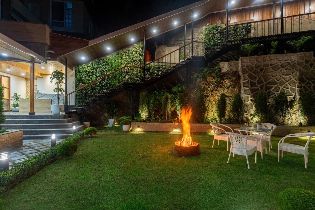 a backyard with a fire pit in the grass at Alaya Stays 6 BHK With Garden - Evaara Woods Hilltop in Shimla