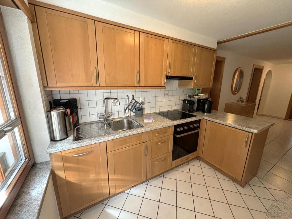a kitchen with wooden cabinets and a sink at Chalet Medi in Zermatt