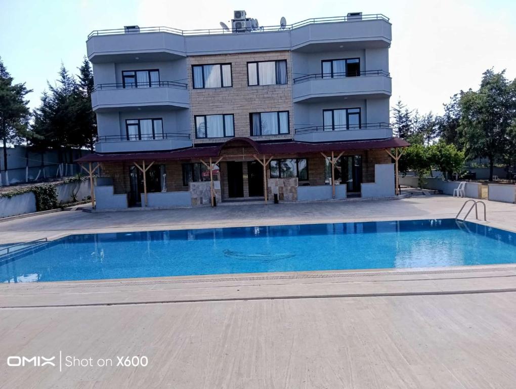 a building with a swimming pool in front of a building at Bayramoğlu Suite in Darıca