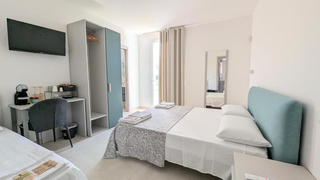 a bedroom with a bed and a desk and a television at L'Ottavo Giorno in Otranto