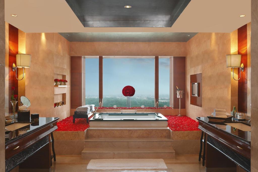 a large bathroom with a tub with a large window at The Leela Ambience Gurugram Hotel & Residences - The Luxury Urban Sanctuary in Gurgaon