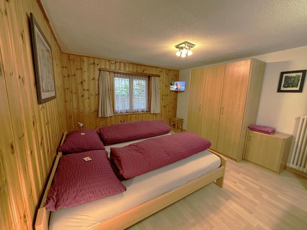 a bedroom with a bed with red pillows on it at Chalet Medi in Zermatt