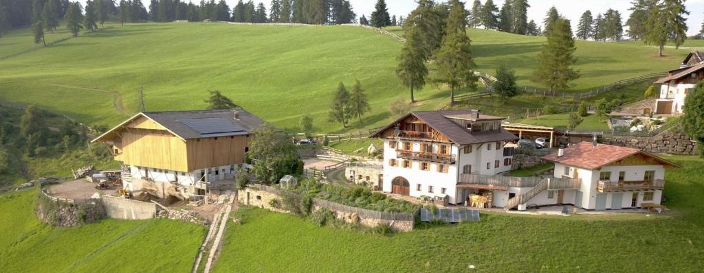 une vue aérienne sur une maison dans un champ verdoyant dans l'établissement Oberfahrerhof Jenesien, à Meltina
