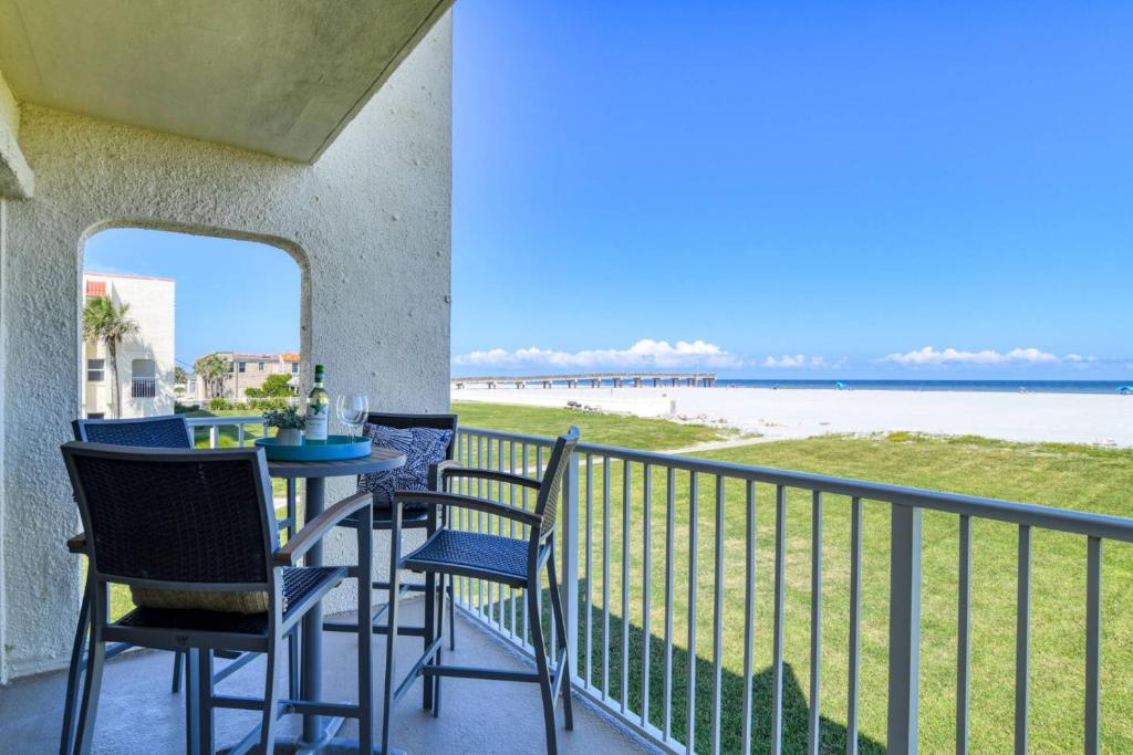 a balcony with a table and chairs and a view of the beach at Pier Point 57 in St. Augustine