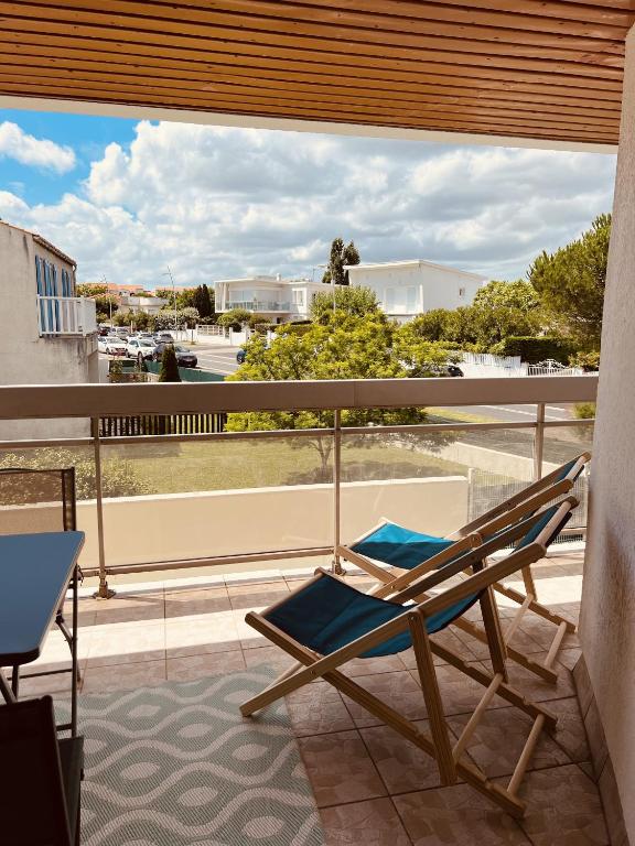 une chaise sur un balcon avec vue sur la rue dans l'établissement Le Cocon, à Vaux-sur-Mer