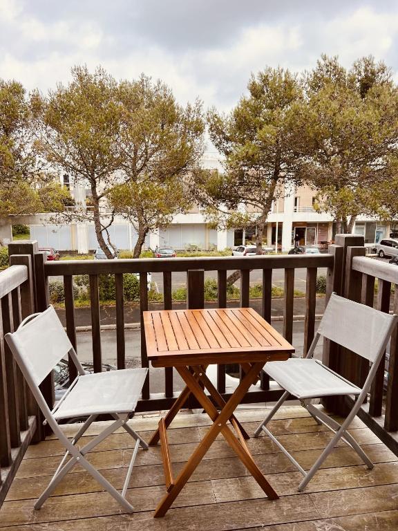 une table en bois et deux chaises sur une terrasse dans l'établissement Charmant Duplex Au Coeur Des Minime, à La Rochelle