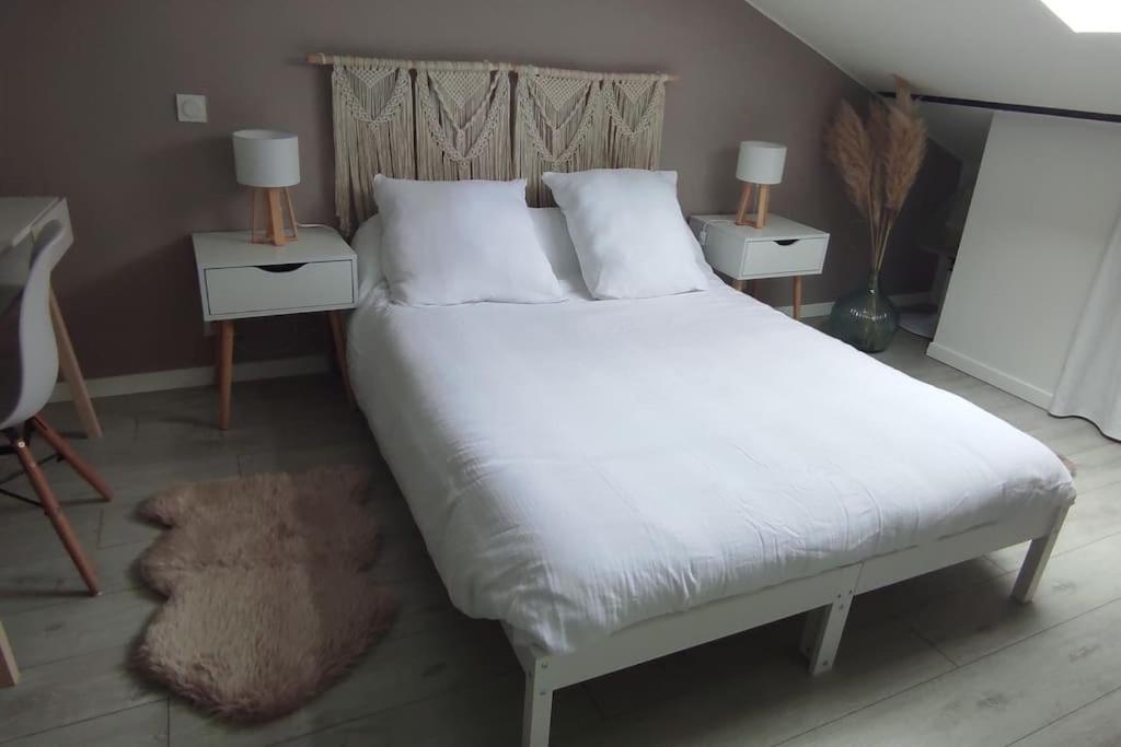 une chambre avec un grand lit blanc avec deux tables de nuit dans l'établissement Le cocon de Rose, à Toulouse