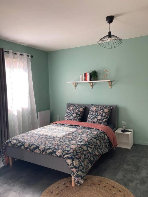 une chambre avec un lit aux murs bleus et une fenêtre dans l'établissement chez karine 6, à Arpajon