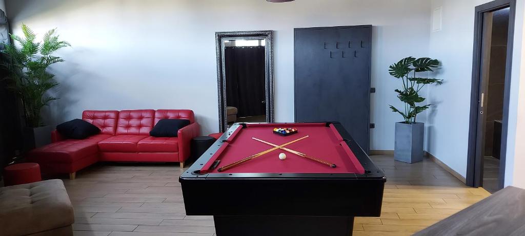 a ping pong table in a room with a red couch at Red room studio app z biljardom in Novo Mesto