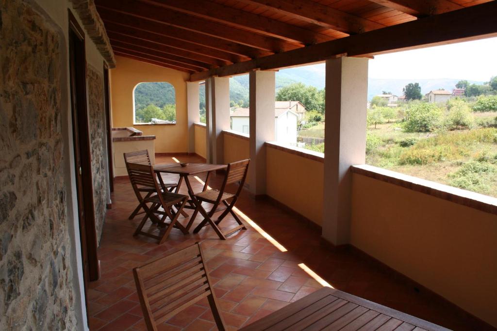 a room with a table and chairs on a balcony at Country House B&B Antica Dimora Del Sole in Camerota