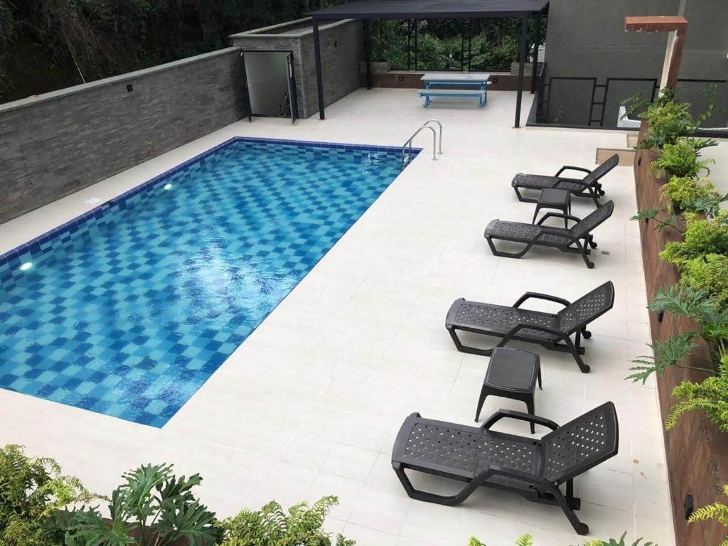 a swimming pool with chaise lounge chairs next to it at Espectacular apartamento en armenia zona norte in Armenia