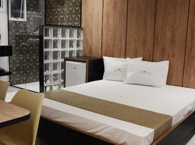 PoáHotel Cereja的一间卧室设有一张带木墙的大床