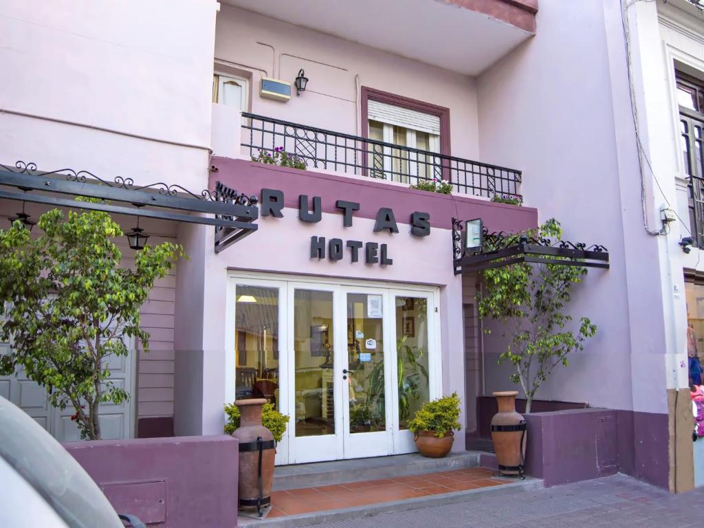 a hotel with a purple sign on the side of a building at Rutas Hotel in Salta