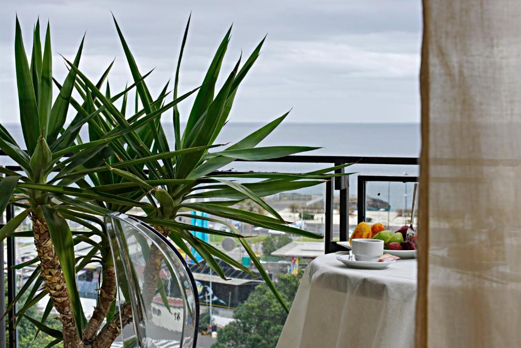 a table with a plate of fruit and a plant on a balcony at Venere B&B in Catania