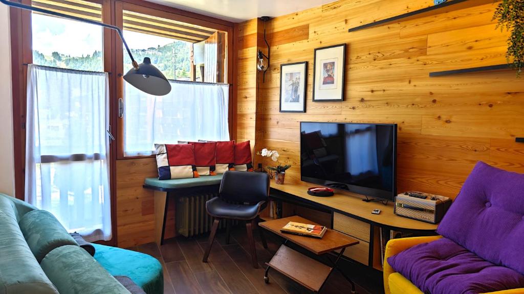a living room with a couch and a desk with a television at Hostdomus - Copenaghen Suite in Sestriere