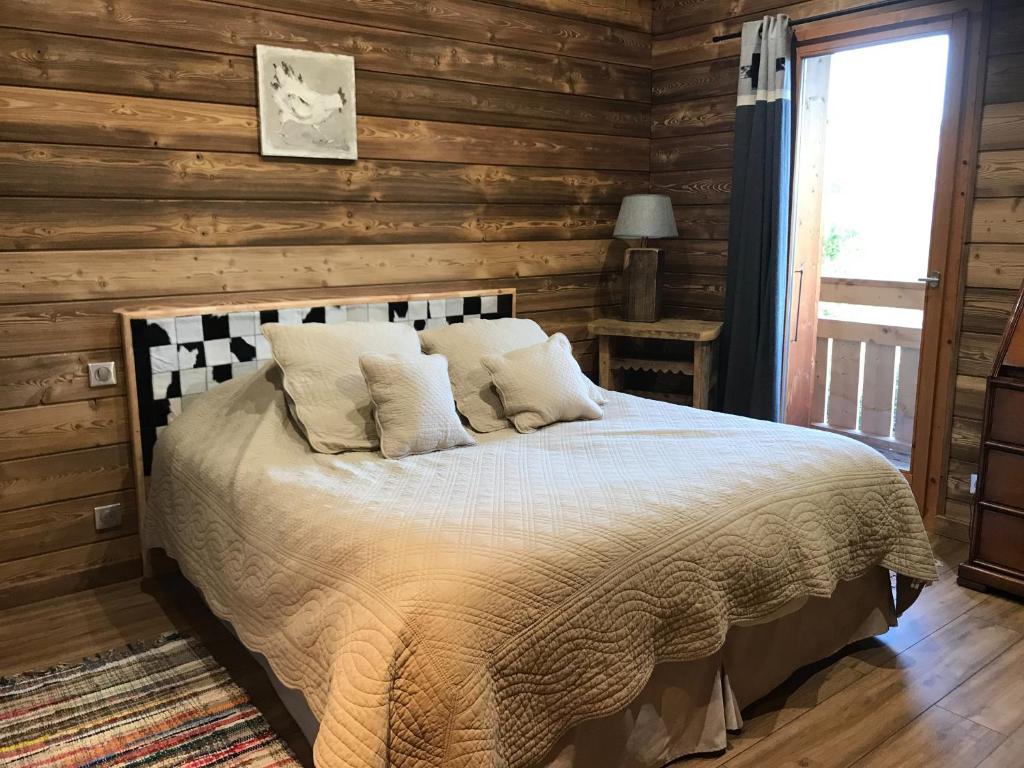 une chambre avec un lit dans une cabane en rondins dans l'établissement Chalet Velajule, à Manigod