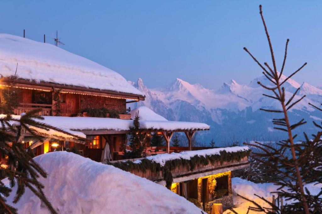 マニグードにあるChalet Velajuleの山々を背景に雪に覆われた建物
