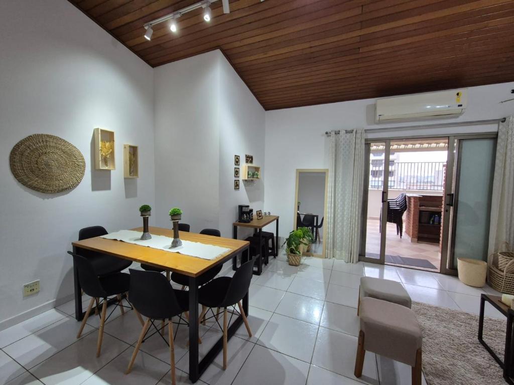 a dining room with a wooden table and chairs at Cobertura 3 quartos c Piscina Privativa e Churrasqueira in Guarujá