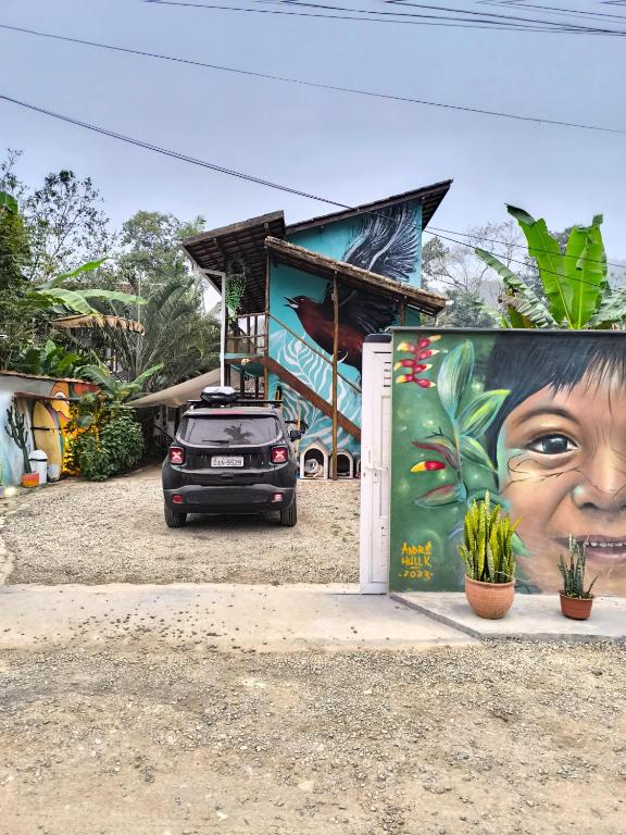 a car parked in front of a building with a mural at Guest House Vida Vibra in Ubatuba
