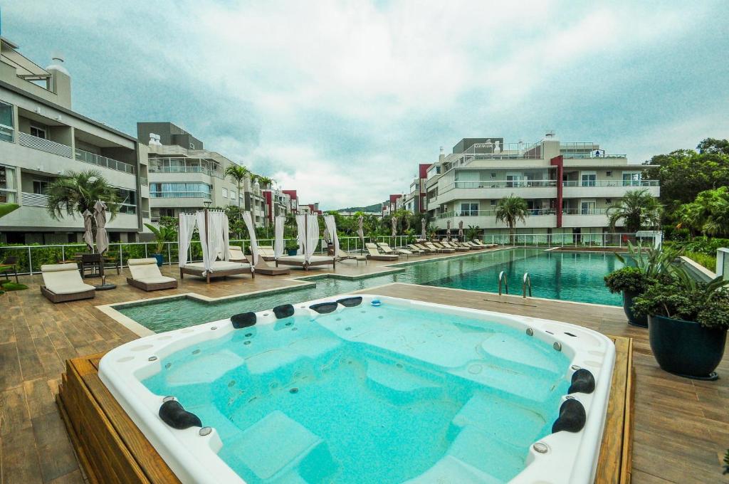 a swimming pool with a hot tub in a building at Thai Beach Home Spa: Apto 200m da Praia N605 in Florianópolis