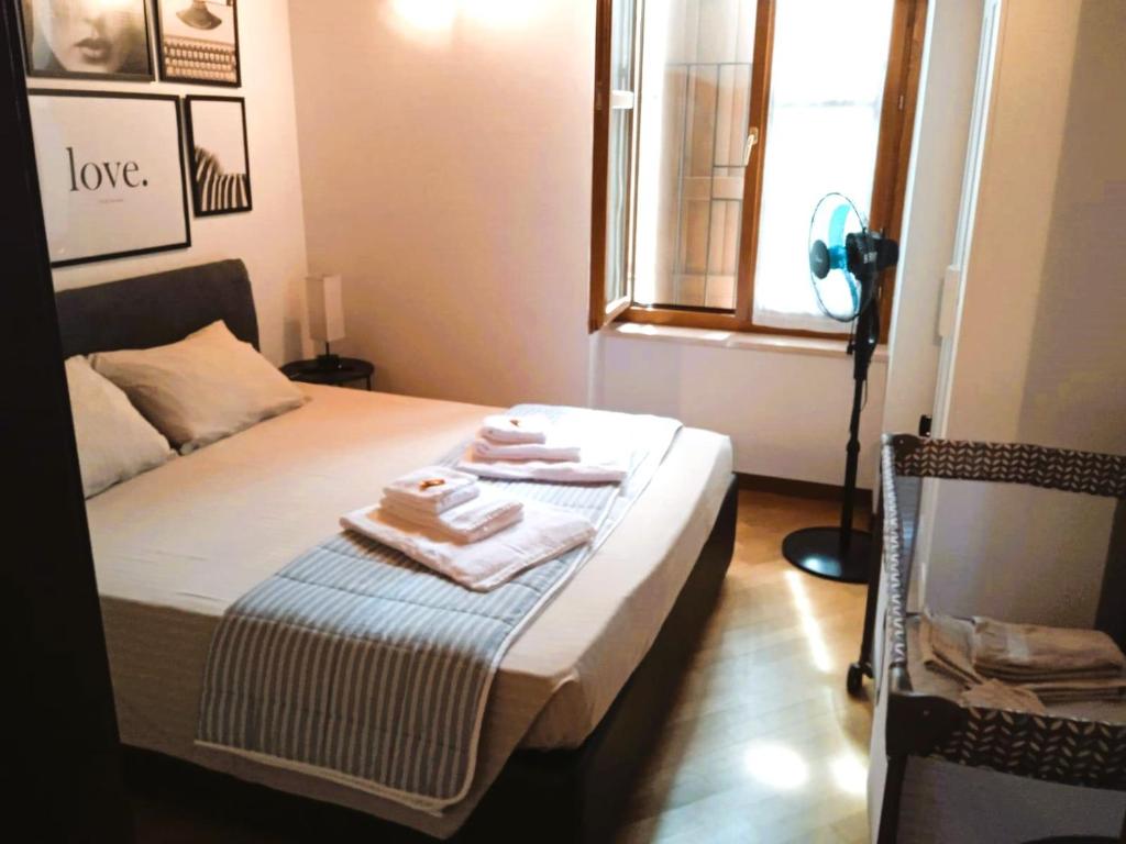 明乔河畔的瓦雷奇奥Casa Linda - Vicino al parco Sigurtà e Valeggio的一间卧室，床上有一张带毛巾的床