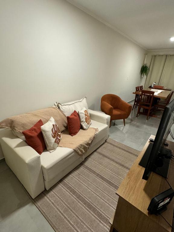 a living room with a white couch with pillows on it at Casa no centro in Serra Negra